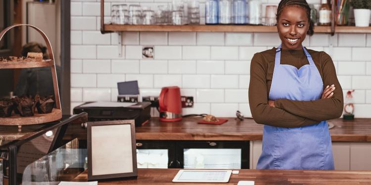 A woman standing behind the counter in her cafe