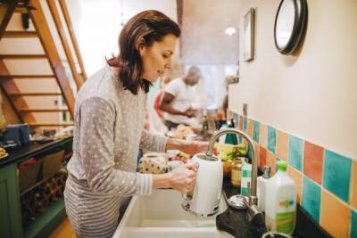 Woman filling kettle at the sink.