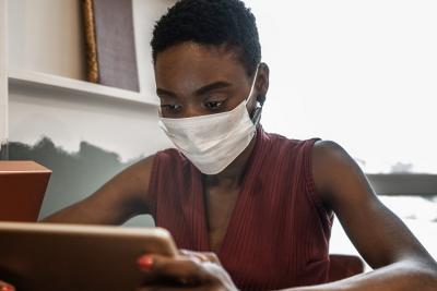 Female reading tablet with mask